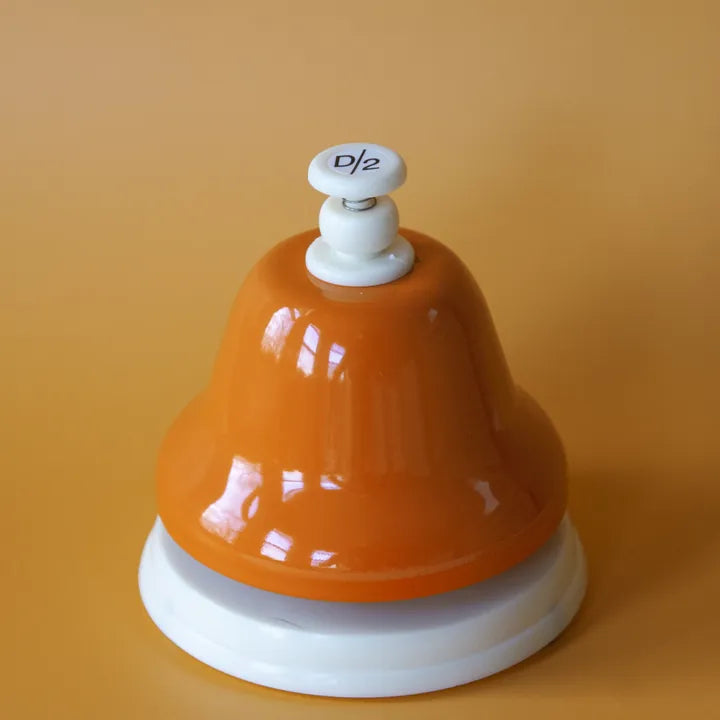 The orange D deskbell on an orange background