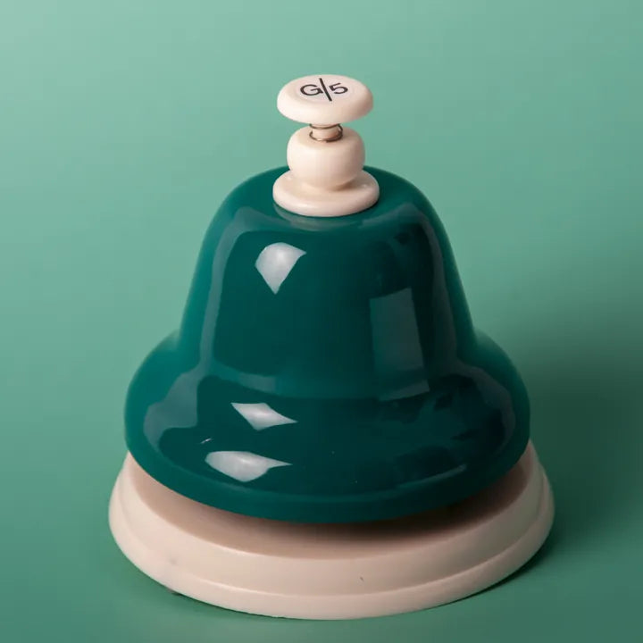 The teal G deskbell on a teal background